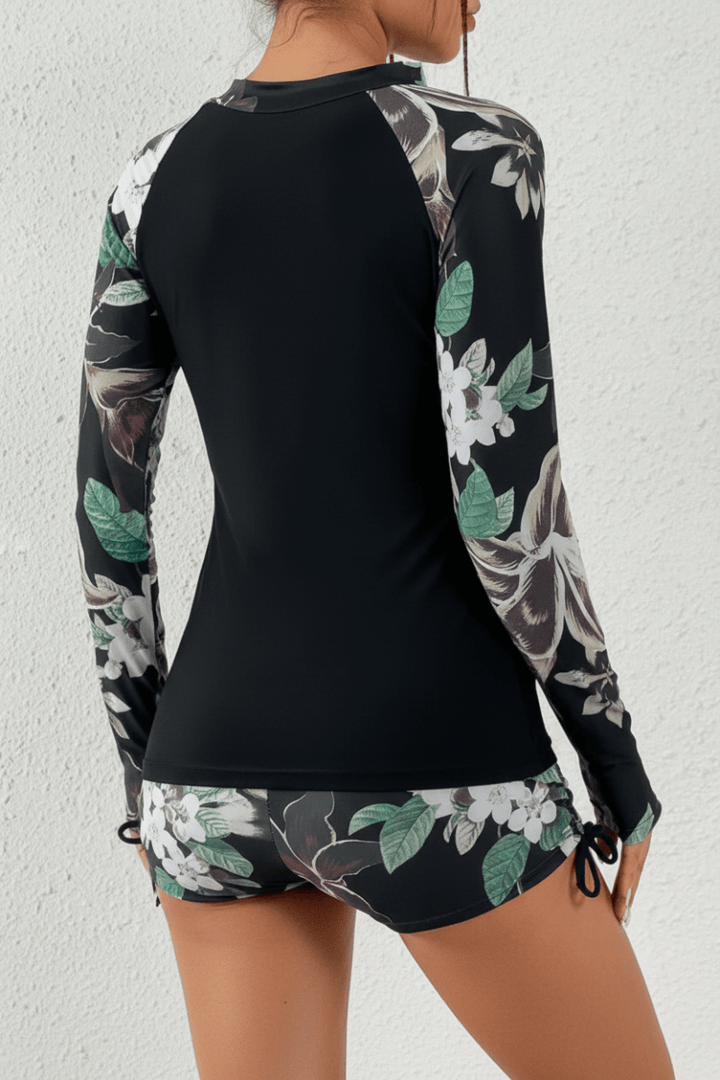 Two-piece women's swimwear featuring a rashguard top and matching shorts in a stylish tropical pattern.