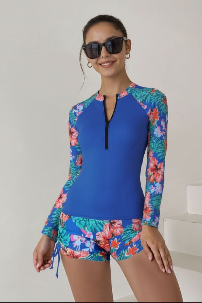 Women's tropical print rashguard swimsuit, a two-piece design offering flattering style and UV protection for summer.
