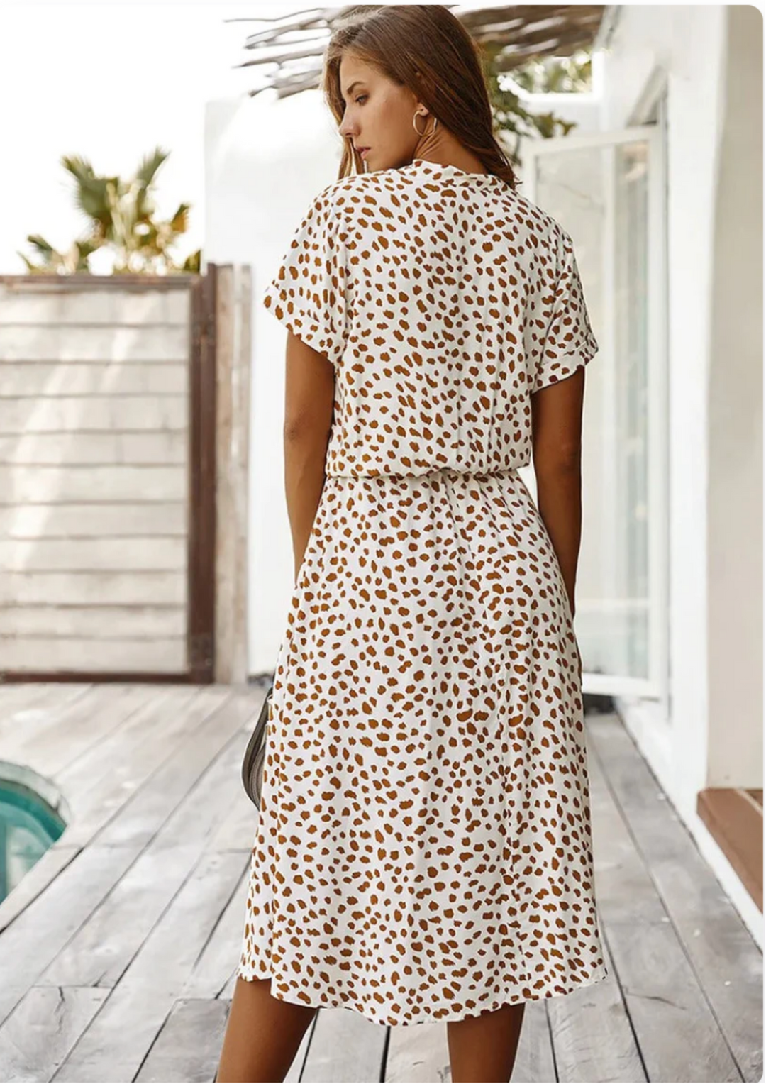 Elegant women's spotted midi dress with a V-neck, button details, and a comfortable, relaxed fit. Casual fashion.