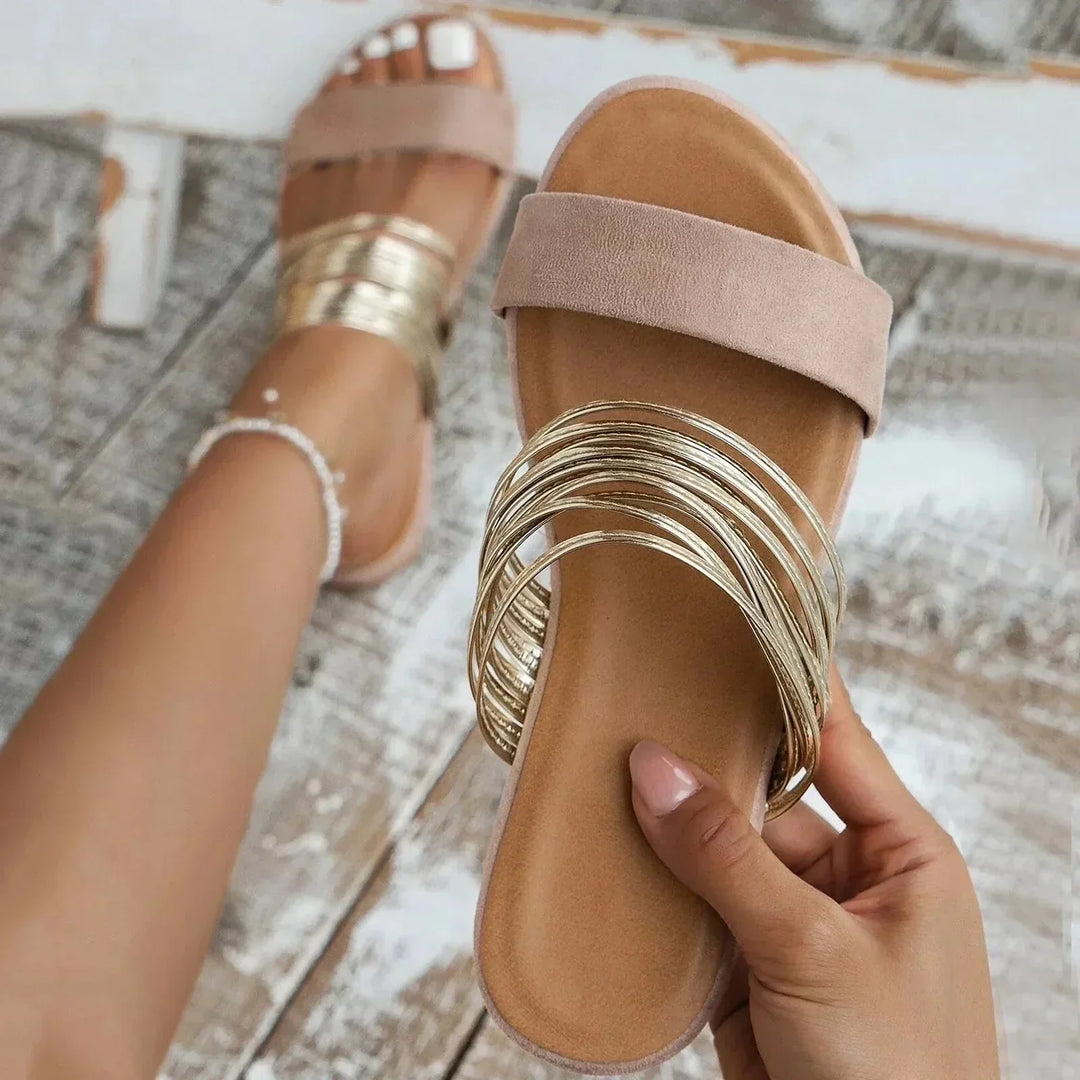 Comfortable women's slip-on flat sandals featuring a chic strappy design, ideal for summer beach and casual wear.