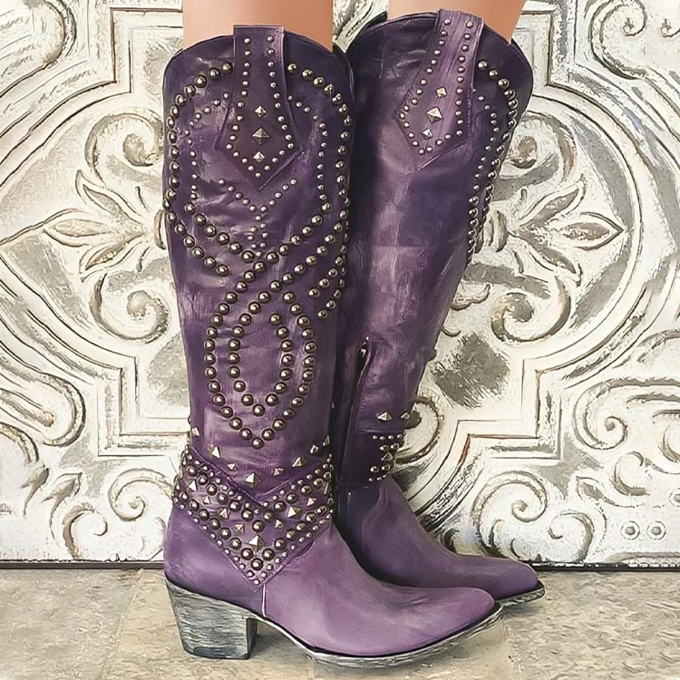 Women's studded knee-high western cowboy boots with a pointed toe and block heel, perfect for festival fashion.