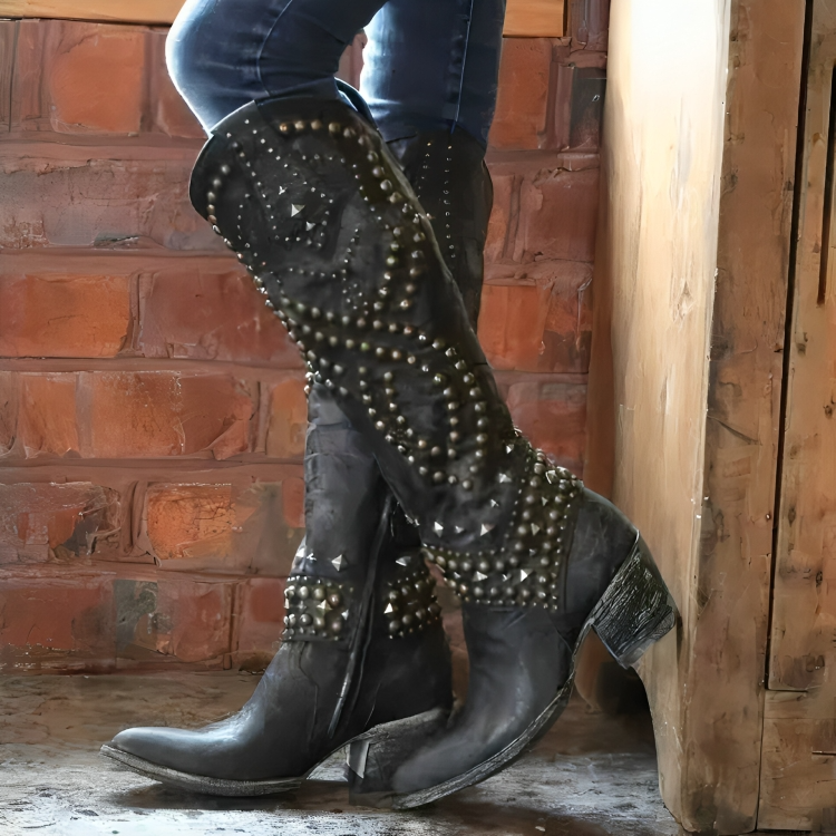 Detailed studded women's knee-high western cowboy boots, with a pointed toe and sturdy block heel.