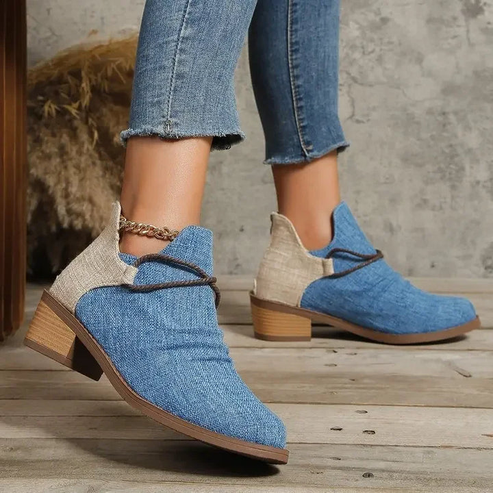 Denim blue women's ankle boots, front view, showcasing braided trim. Stylish & comfy footwear.
