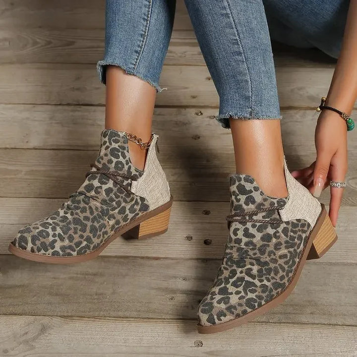 Leopard print women's ankle boots, side view, with braided detail & block heel. Trendy choice.
