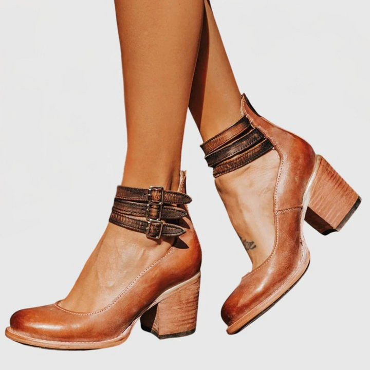 Casual yet chic women's block heel boots with unique cutout details and decorative buckle straps for versatile wear.