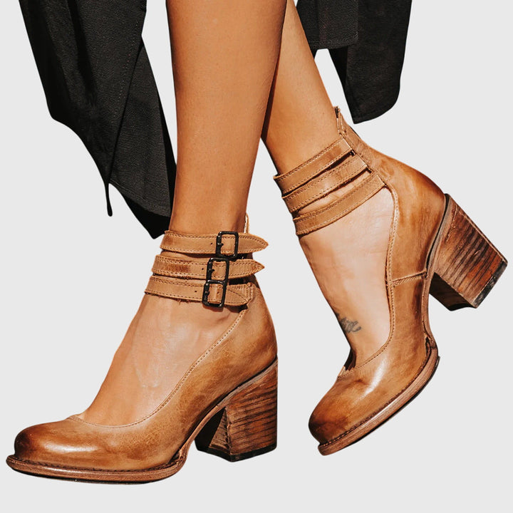 Stylish women's fall/winter boots: black ankle boots with a comfortable block heel and cool buckle strap cutouts.