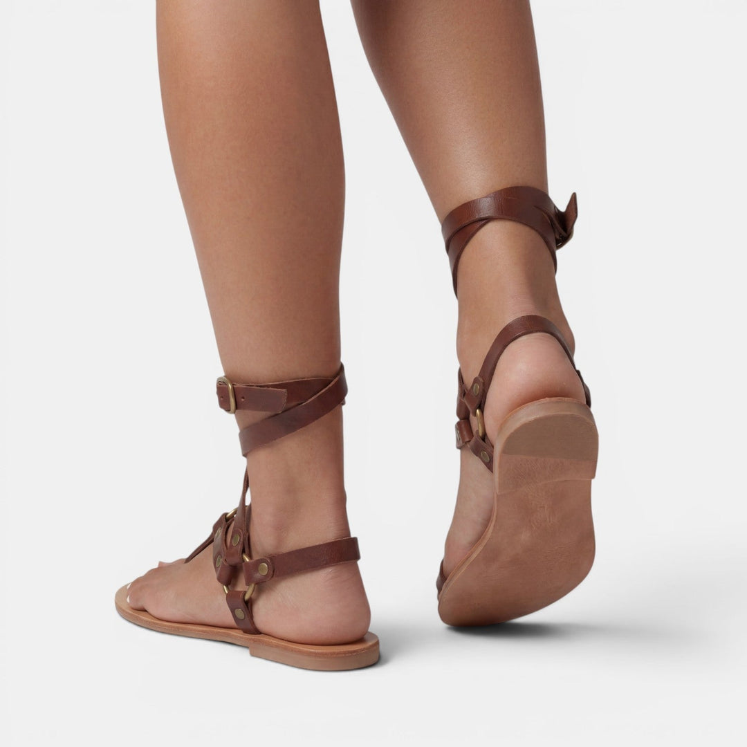 Comfortable women's snake print flat sandals with buckled crossover straps, ideal for casual summer style.