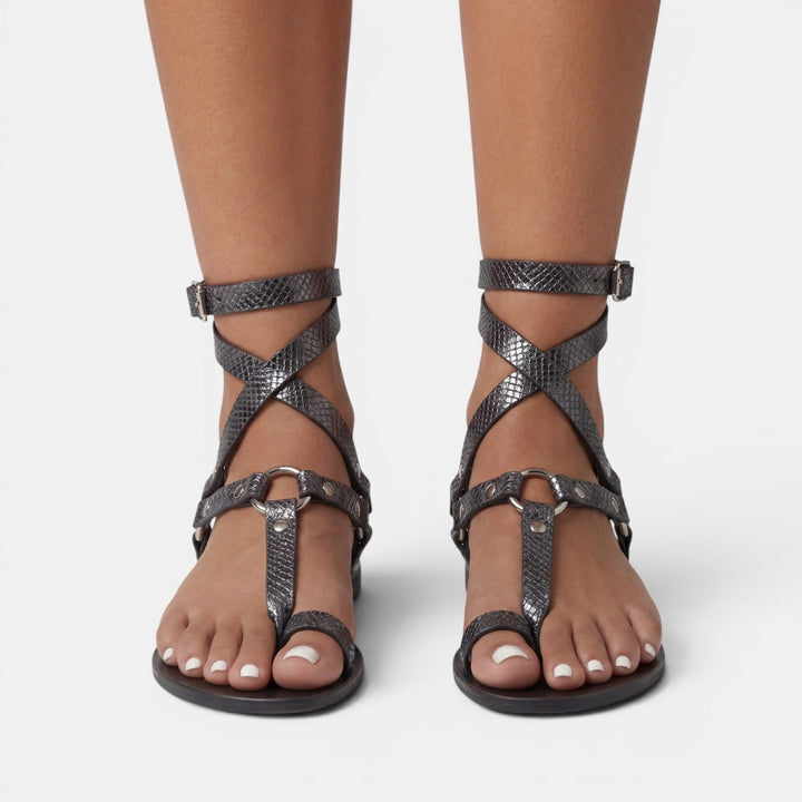 Vacation-ready women's snake print flat sandals, offering all-day comfort with chic crossover straps & buckle.