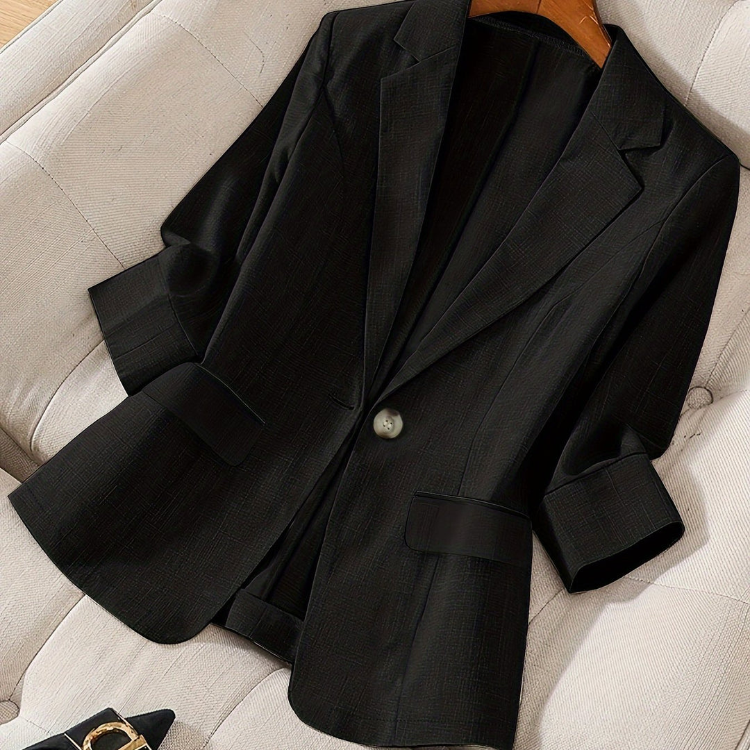 Woman in a tailored cropped blazer paired with smart trousers, ideal for office elegance.