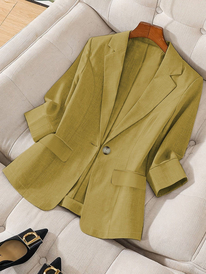 Detailed view of the sleek lapels and button on this modern women's cropped blazer.