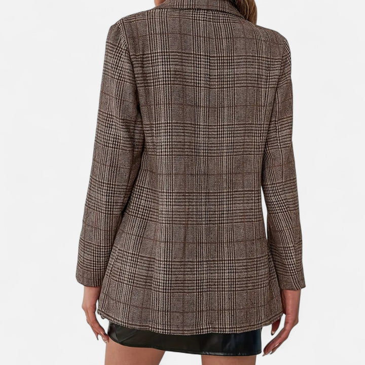 Woman wearing a sophisticated tailored plaid blazer. Ideal for professional office wear and chic evening fashion.