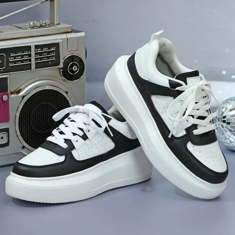 Modern white platform sneakers for women, showcasing perforated upper and classic lace-up design for fashion footwear.