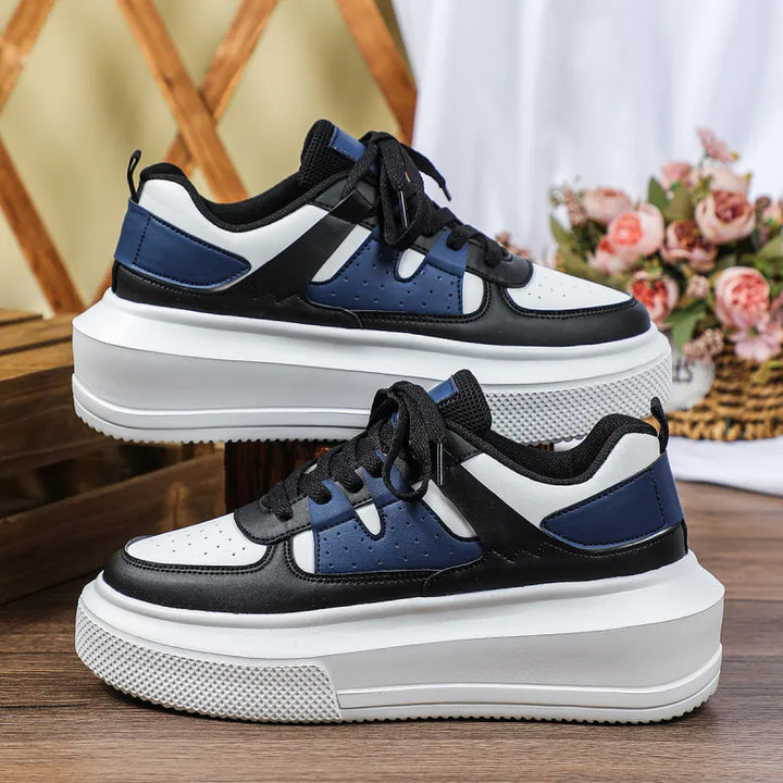 Close-up of white women's platform sneaker detailing perforated upper, thick sole, and classic lace-up closure.