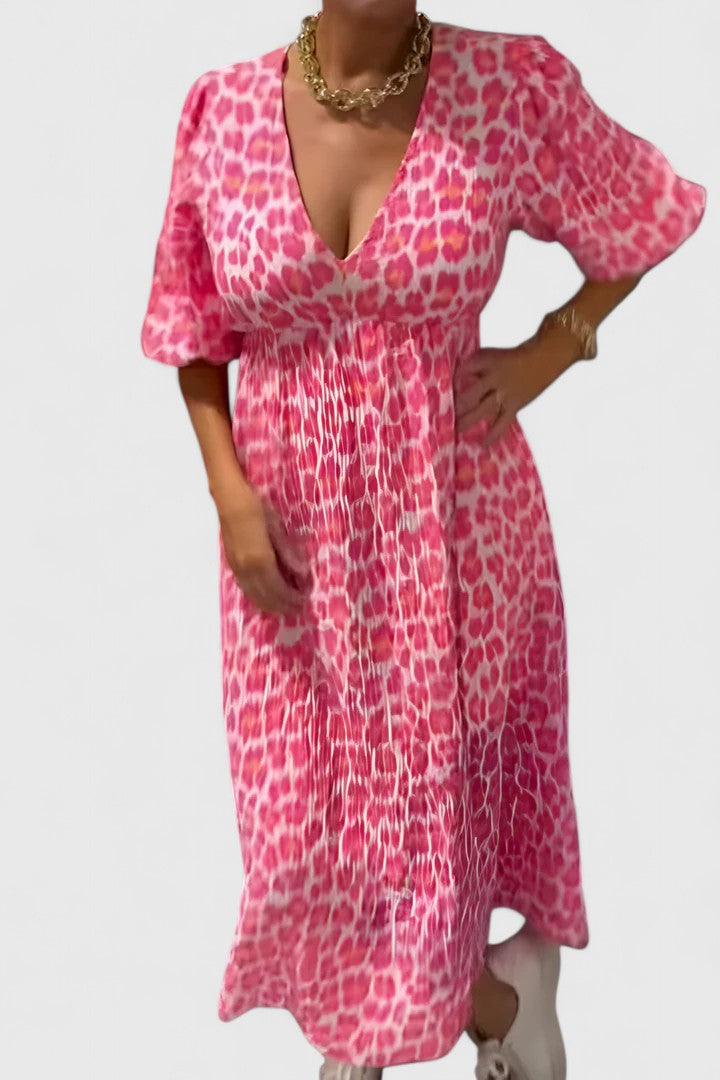 Elegant flowing tropical stripe maxi dress for women. V-neck, puff sleeves, comfortable resort & beach vacation wear.