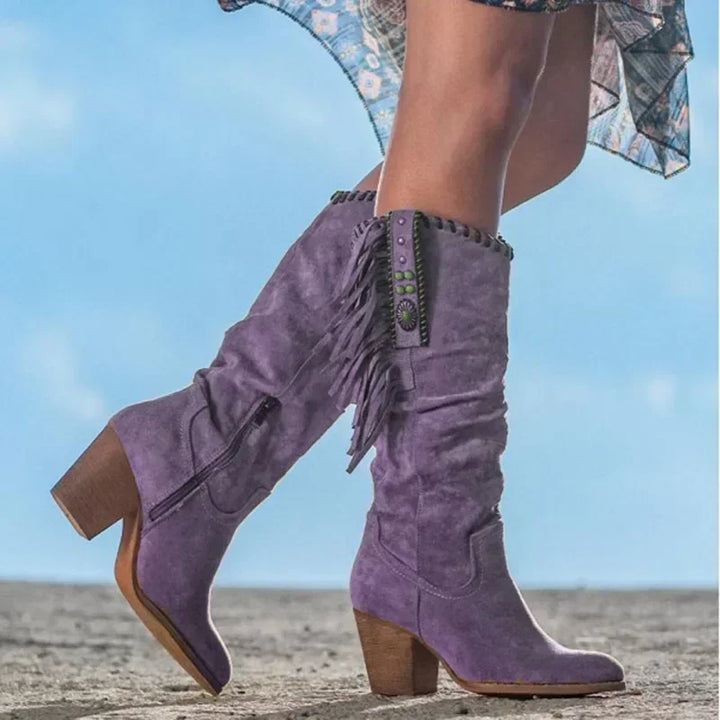 Stylish women's mid-calf western boots. Features turquoise, fringe, and stud details, pointed toe.