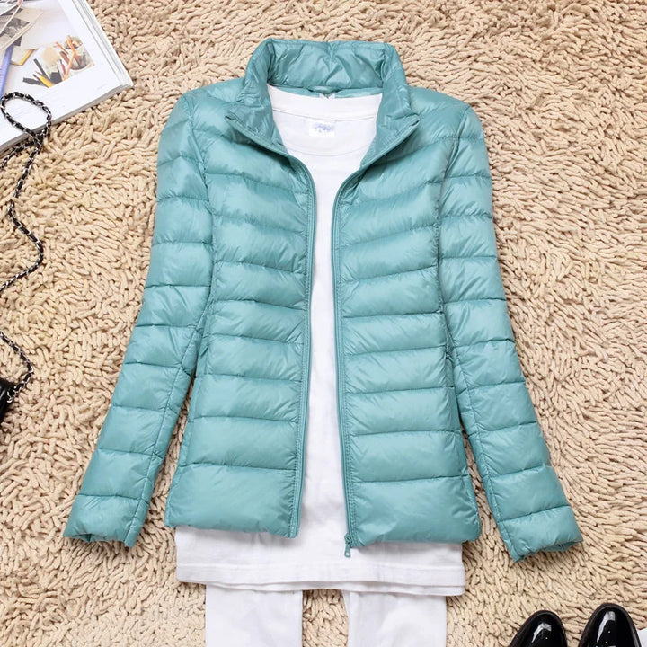Active women's hooded jacket, ultralight insulated design for outdoor adventures and winter comfort.
