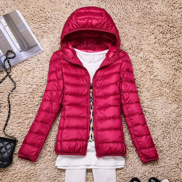 Durable women's ultralight insulated hooded jacket, designed for winter outdoor activities & warmth.