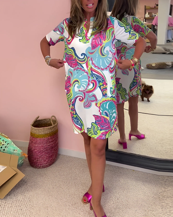 Flowy women's v-neck draped dress with a vibrant print. Comfortable, versatile & offers a flattering fit for day wear.