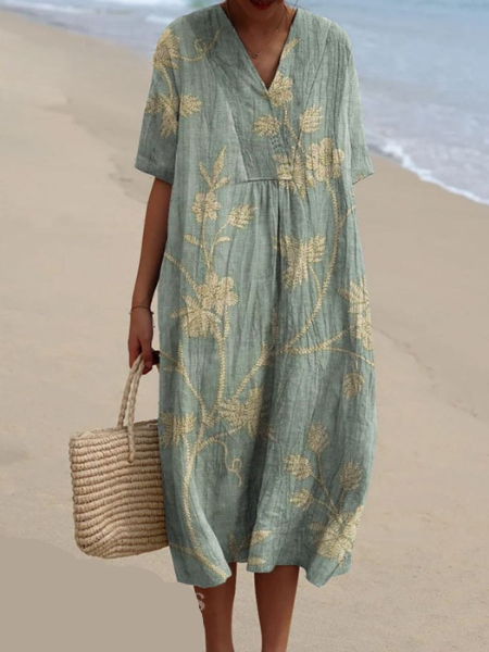 Women's floral V-neck midi dress styled with sandals & a hat, perfect for summer vacation.