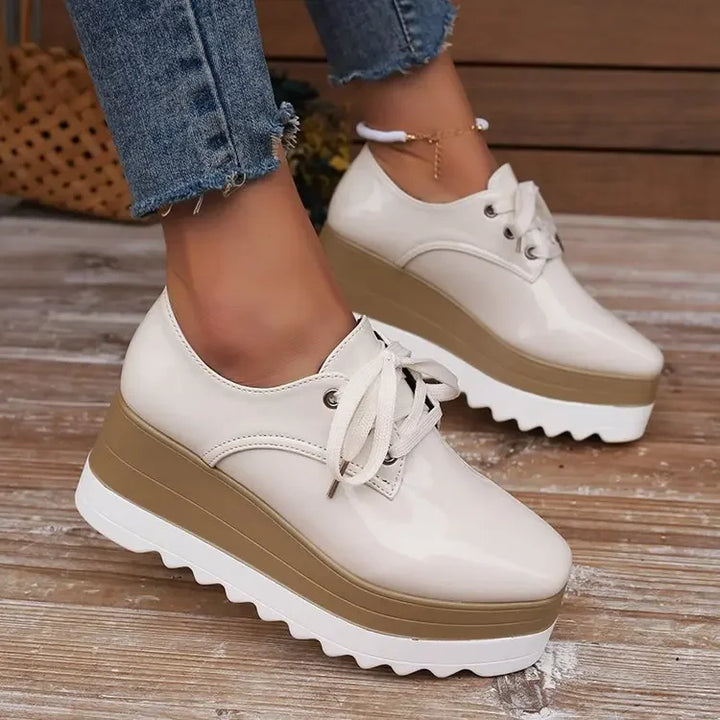 Verona Gloss women's platform sneakers, highlighting glossy texture & lace-up detail. Chic casual footwear.