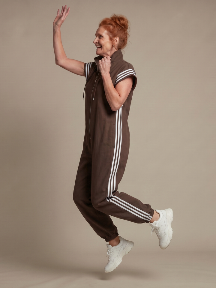 Modern women's one-piece striped jumpsuit with a stylish zip front and cap sleeves.