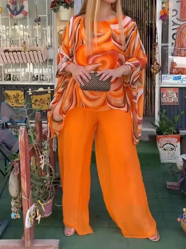 Fashionable women's resort wear: abstract print batwing top and elegant wide leg pant set.
