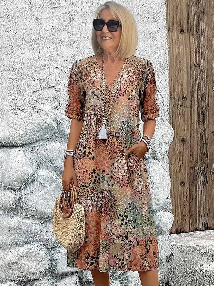 Stylish women's vibrant print midi dress with a comfortable flowy design. Features pockets; great for summer parties.
