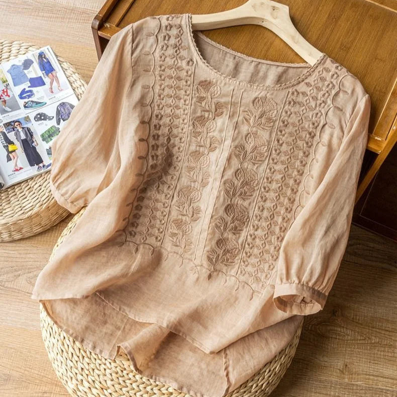 Close-up of vintage embroidered details on a women's blouse with delicate sheer puff three-quarter sleeves.
