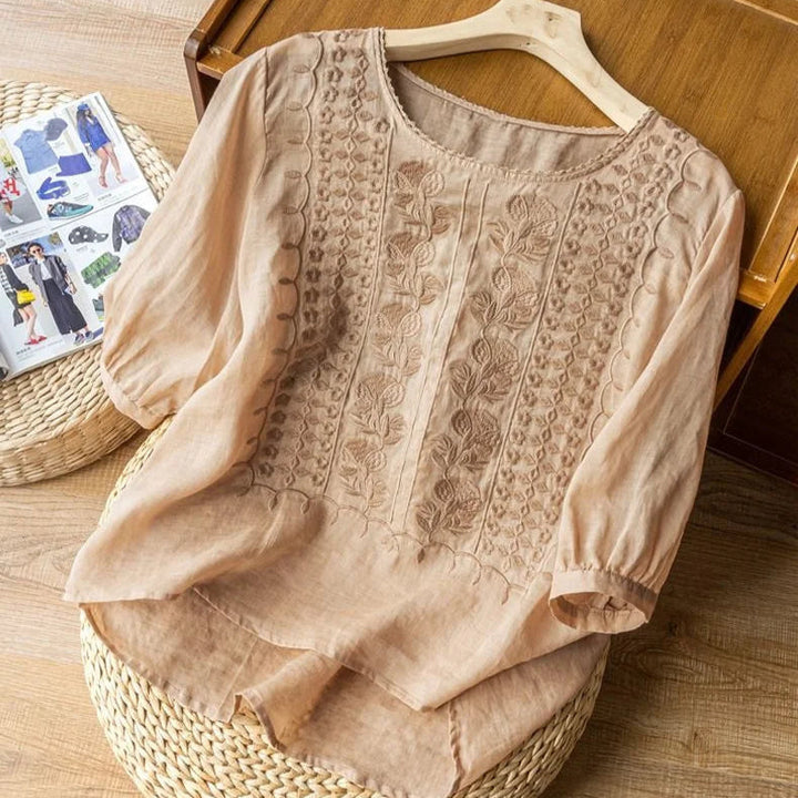 Close-up of vintage embroidered details on a women's blouse with delicate sheer puff three-quarter sleeves.
