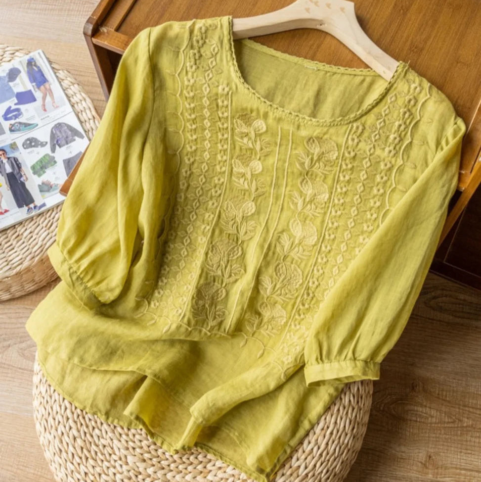 Chic women's vintage style top with delicate embroidery and sheer puff sleeves, a feminine summer fashion piece.