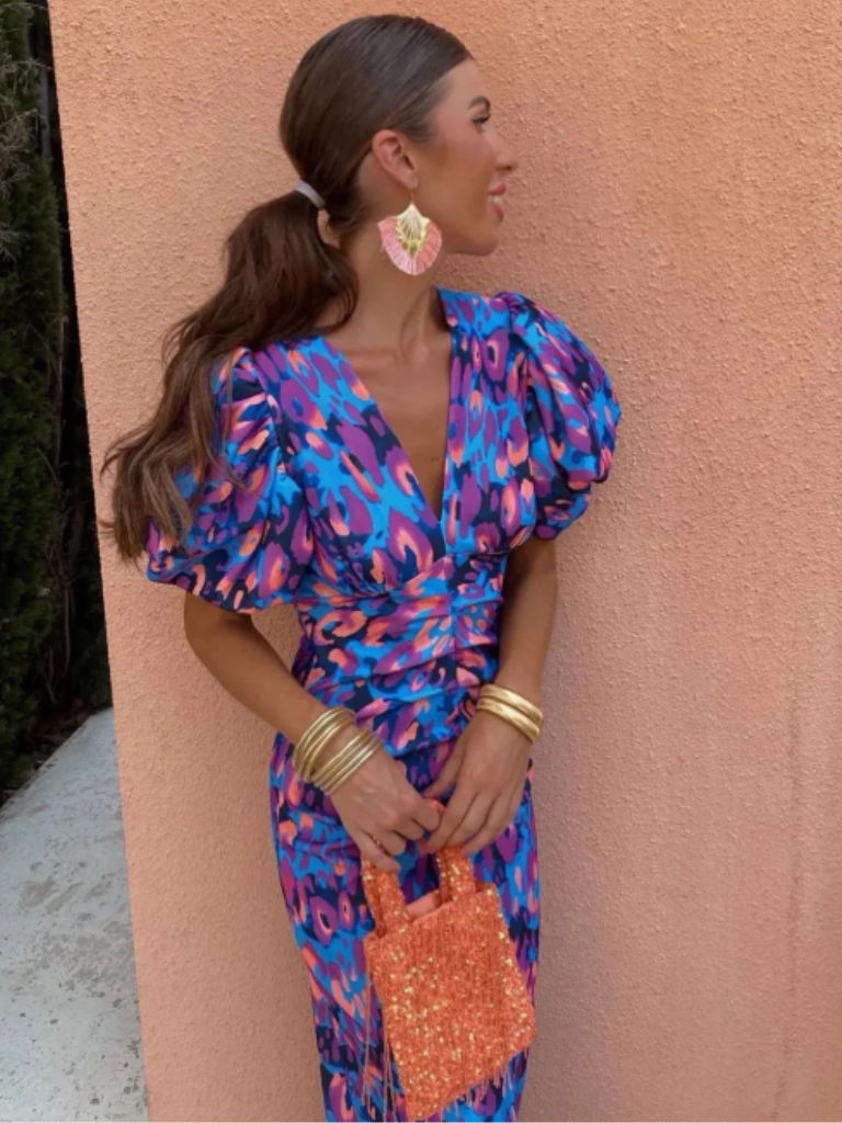 Vivid ruched midi dress with bold abstract print. Flattering women's fashion for statement occasion wear.