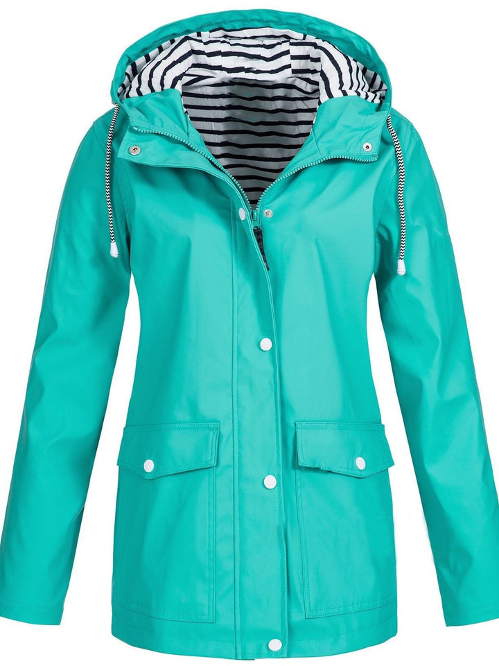 Close-up of the waterproof fabric & zippered pockets on a women's windproof and hooded outerwear jacket.