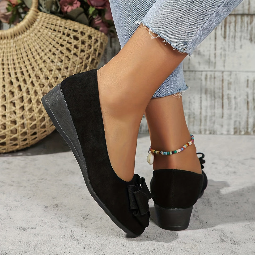 Women's round toe slip-on wedge flats with bow detail, great for casual wear or comfortable walking.