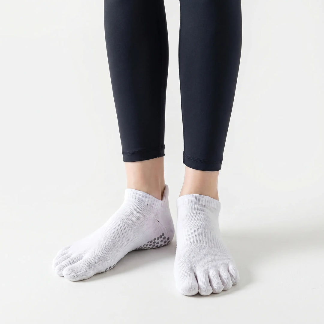 Comfortable white women's five-toe grip socks, ideal for non-slip performance in yoga, pilates & barre classes.