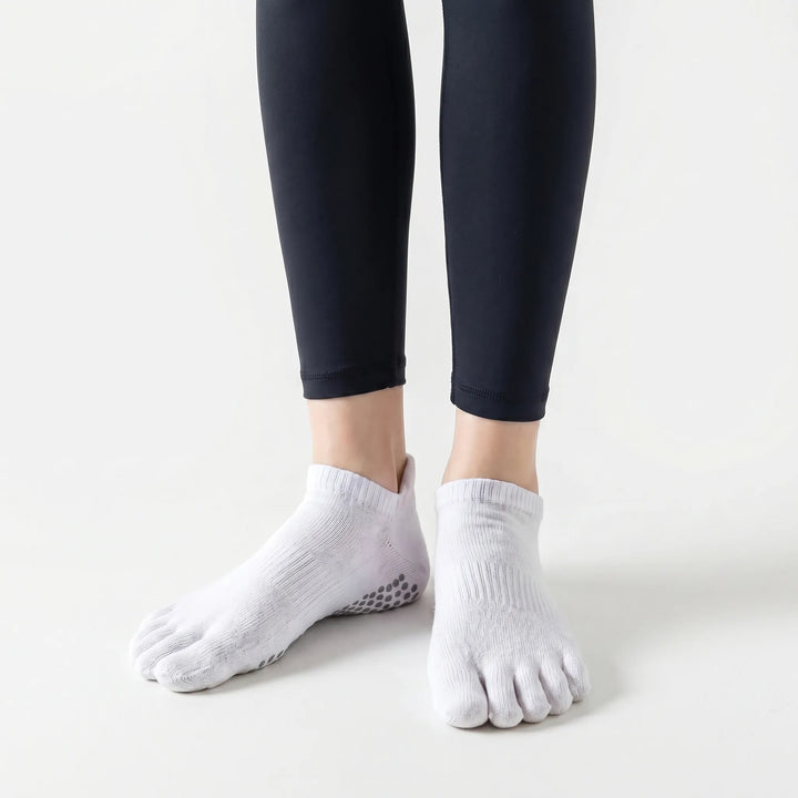 Comfortable white women's five-toe grip socks, ideal for non-slip performance in yoga, pilates & barre classes.