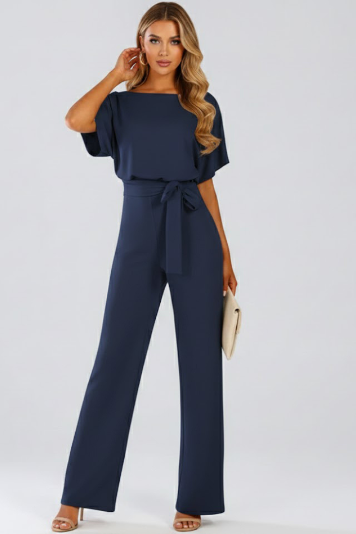 Model in a women's wide leg short sleeve belted jumpsuit, showcasing its casual chic elegance.