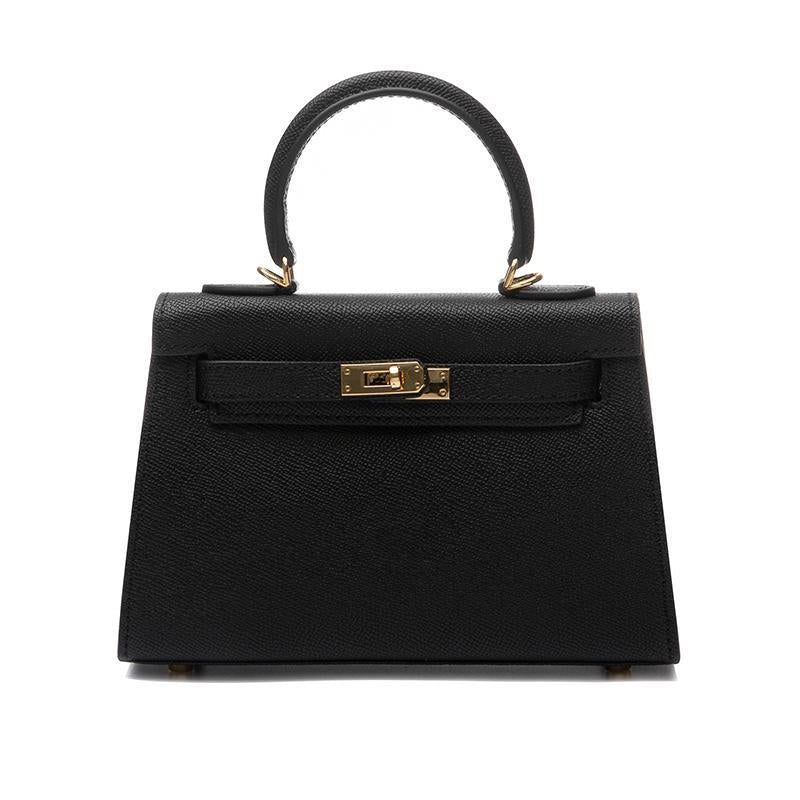 Elegant black structured bag for women, featuring a sturdy top handle, practical turn lock, & adjustable strap.