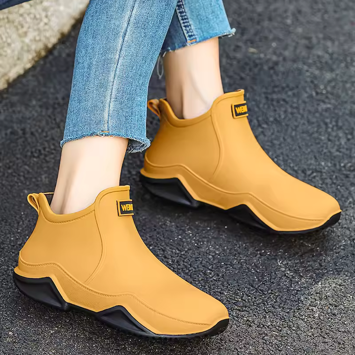 Women's black waterproof slip-on ankle rain boots for wet weather comfort.