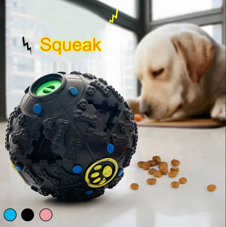 Dog chewing on a red interactive squeaky treat ball, an enriching dogtoy for pets.