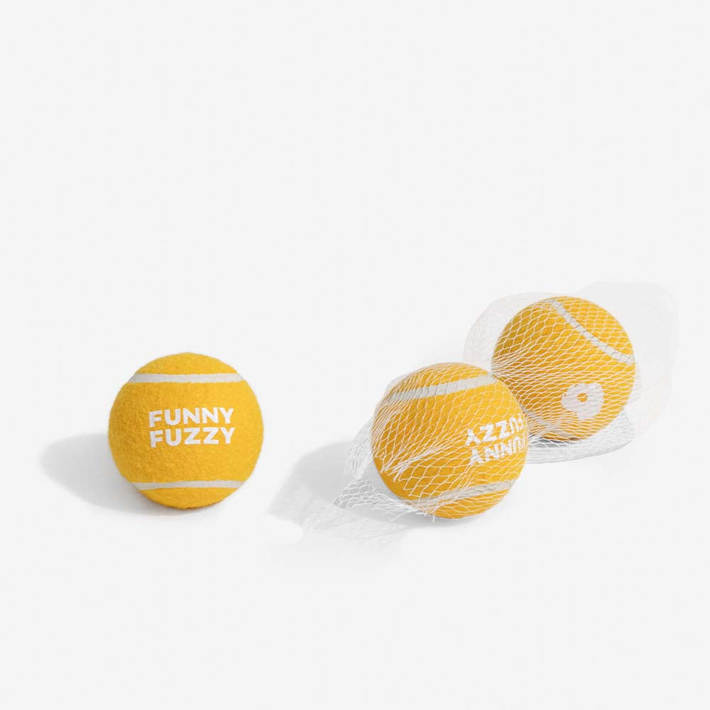 Bright pink squeaky tennis ball dog toy, high-visibility for outdoor fetch games and training.